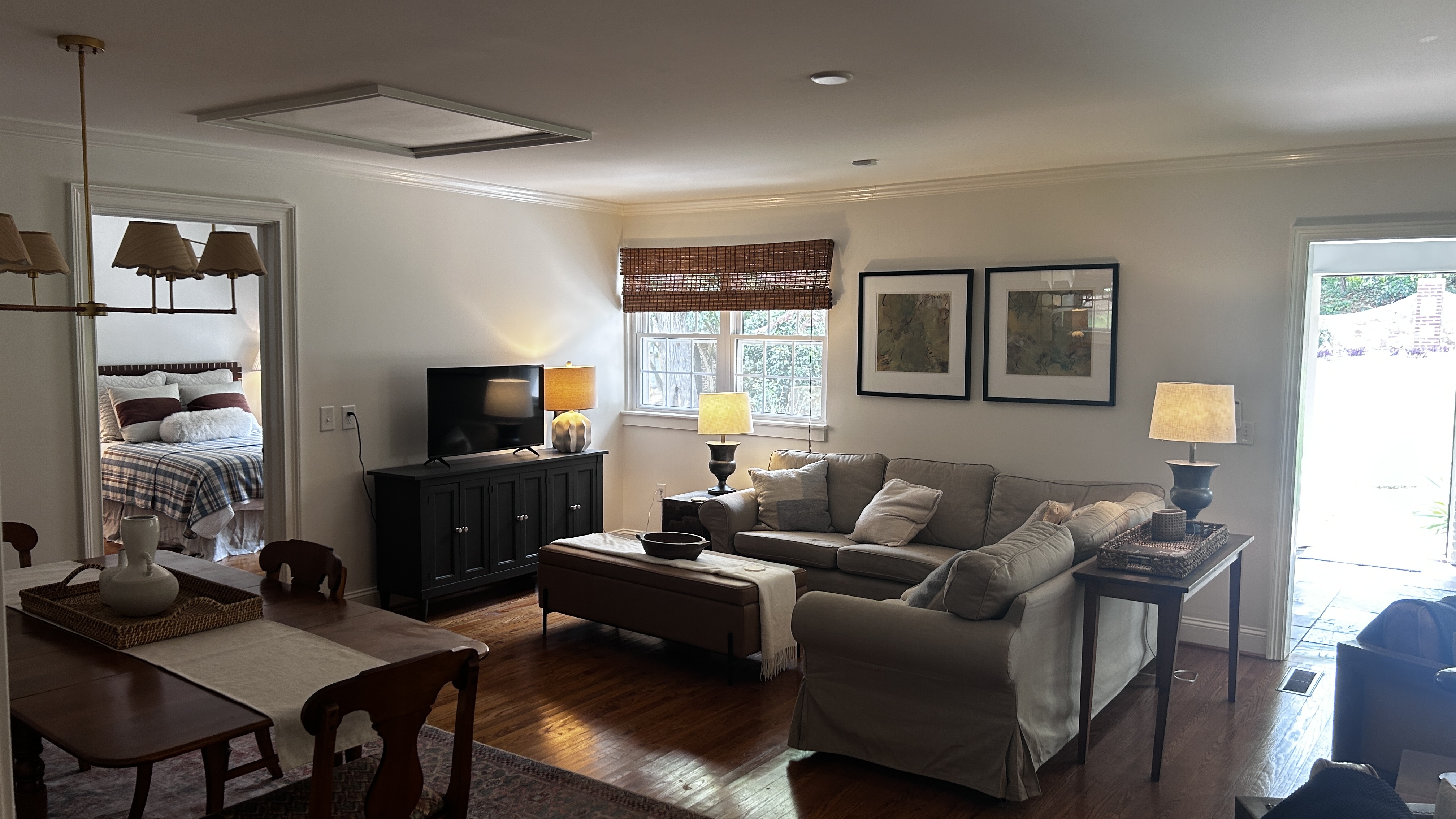 Open living room with hardwood floors, warm lamps and dining table